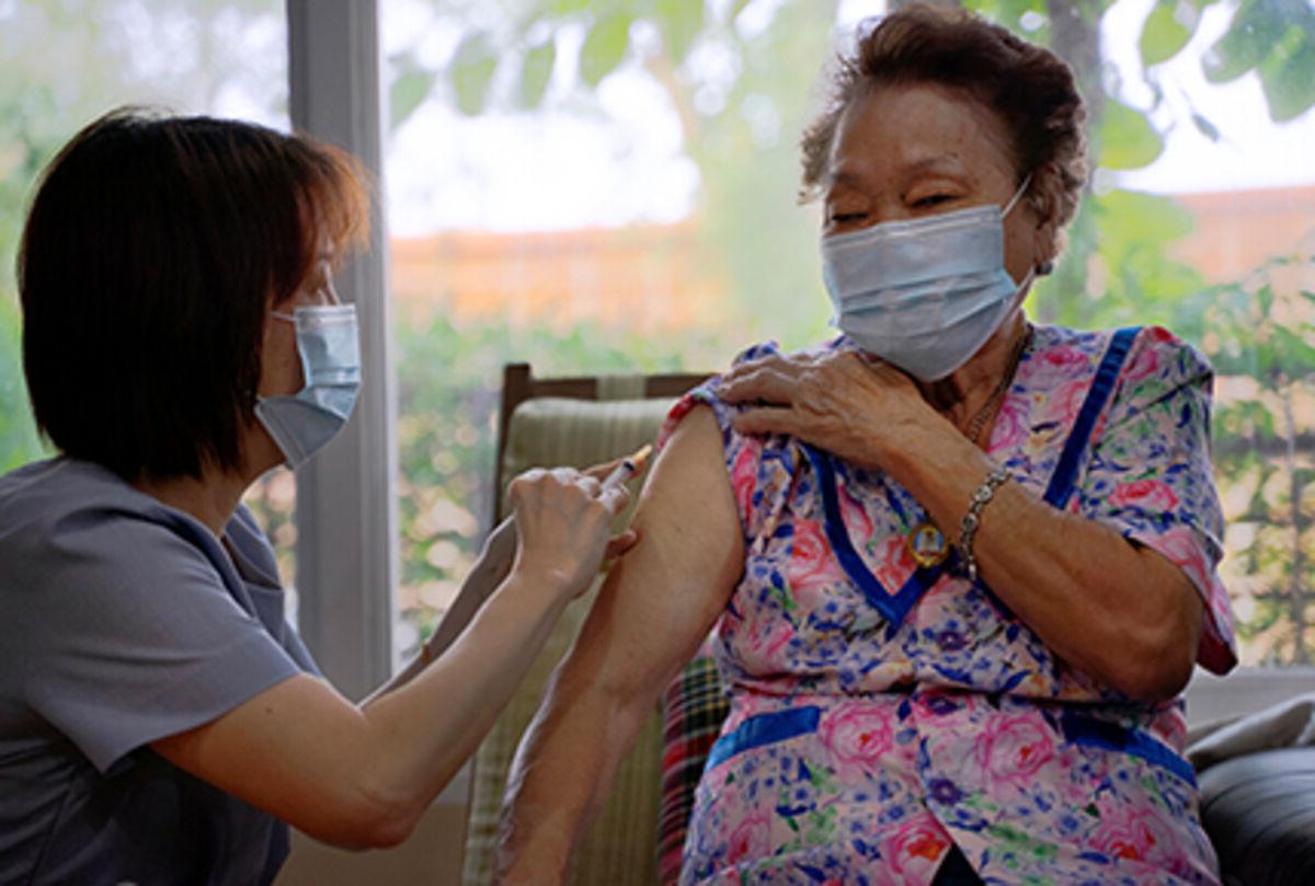 Senior adult receiving a vaccination from a health care professional